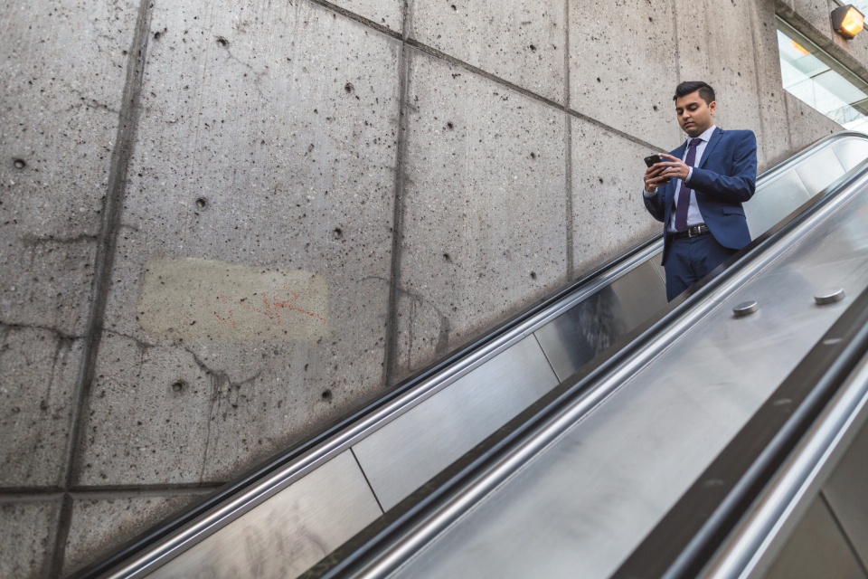 man on escalator on phone